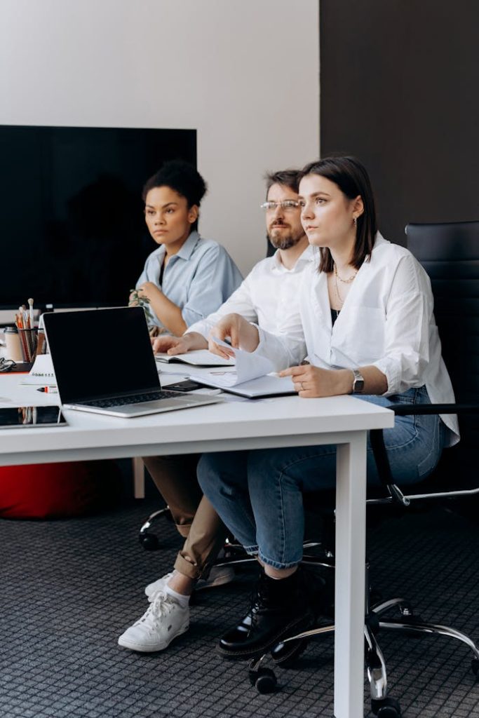 a-group-of-businesspeople-in-a-meeting-6592662 A focused group working together in a modern office setting, promoting teamwork.