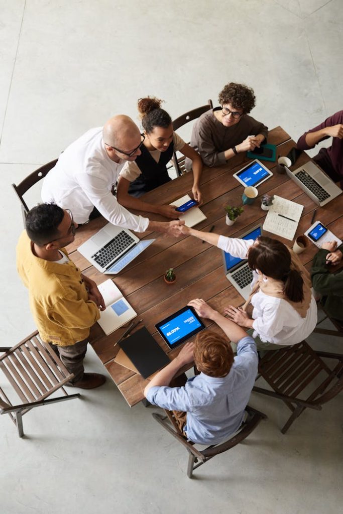 high-angle-shot-of-group-of-professionals-3183172 Overhead shot of a diverse team collaborating in a modern office meeting.